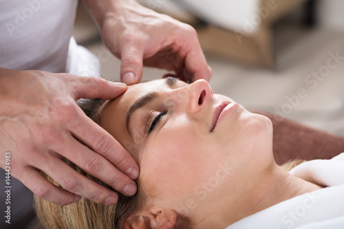 Therapist Giving Massage On Woman's Forehead