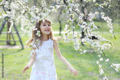 Portrait of happy little girl whith cherry tree flowers