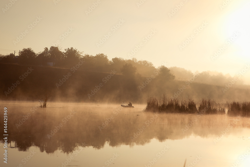 A misty morning by the lake. Small fishing boat at the lake.  Space for text.