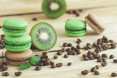 Green and brown french macarons with kiwi, coffee beans and mints decorations