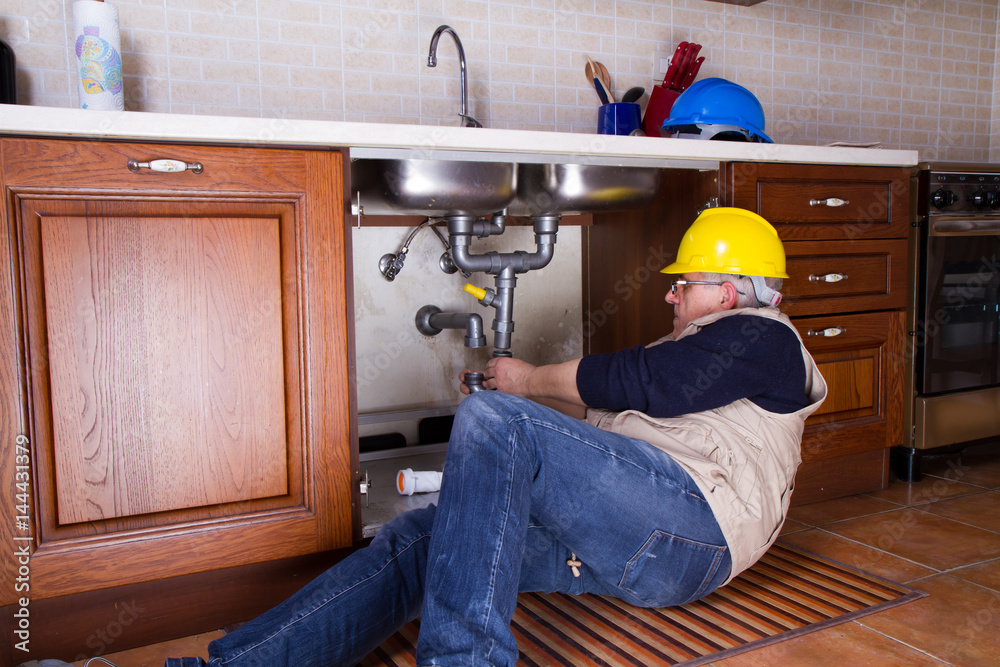 plumber at work to fix a sink plumber at work to fix a sink