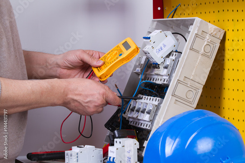 electrician fixing electrical devices with different tools