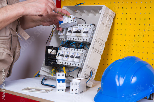 electrician fixing electrical devices with different tools