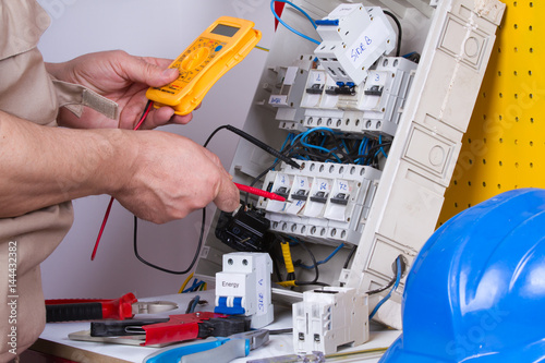 electrician fixing electrical devices with different tools