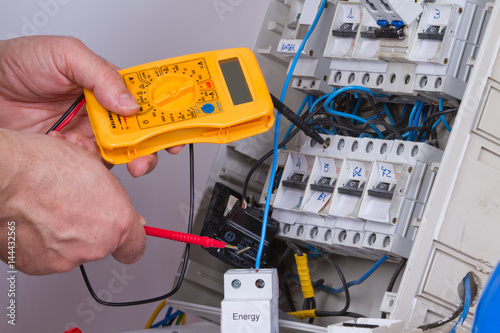 electrician fixing electrical devices with different tools