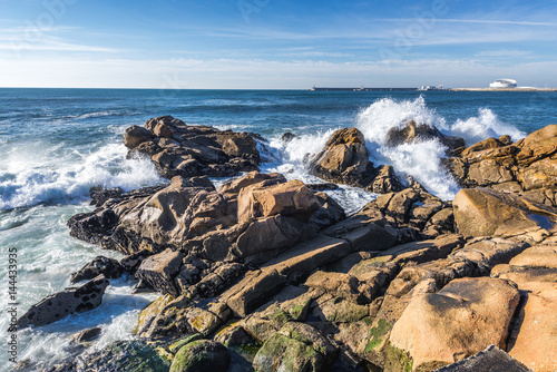 Rocks of Atlantic Ocean seen from beach in Porto, Portugal photo