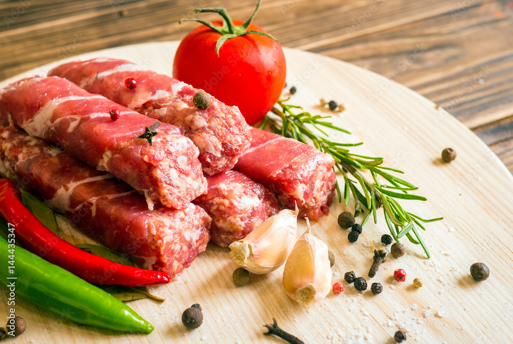 Raw cevapcici dish of mixed meats, the food of the Balkans. Minced meat and bacon. Raw cevapcici dish of mixed meats, the food of the Balkans. Minced meat and bacon.
