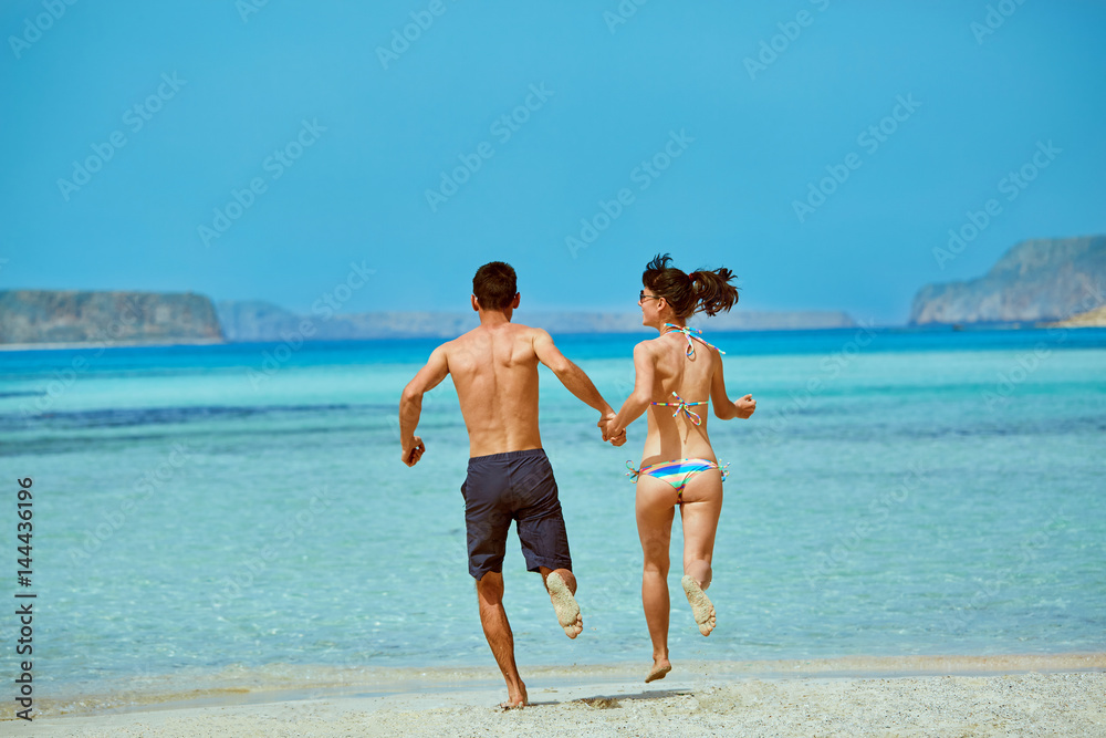 young happy couple running on the beach. Balos beach, Crete, Greece.