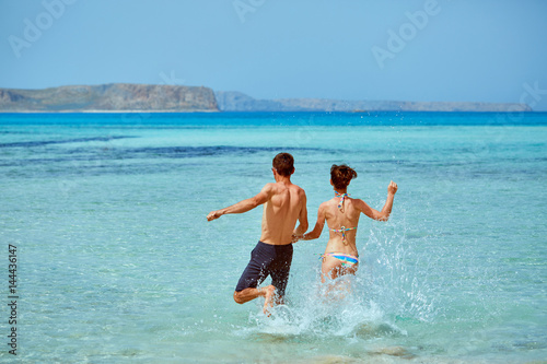 young happy couple running on the beach. Balos beach, Crete, Greece.