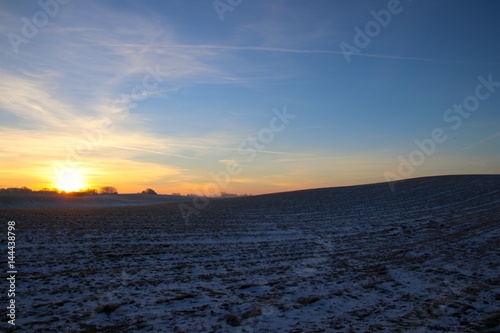 Hilly landscape at sunrise and blue sky in February