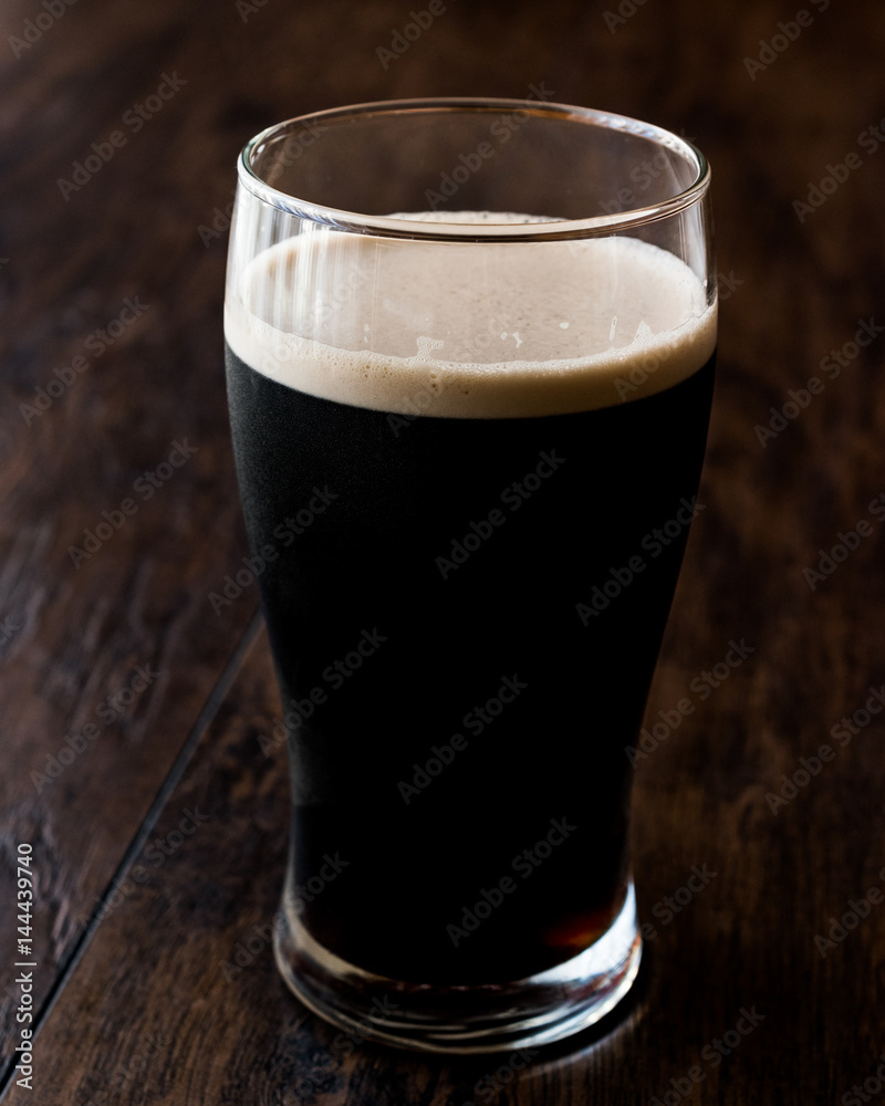 Dark Beer on wooden surface. Close up view. Dark Beer on wooden surface. Close up view.