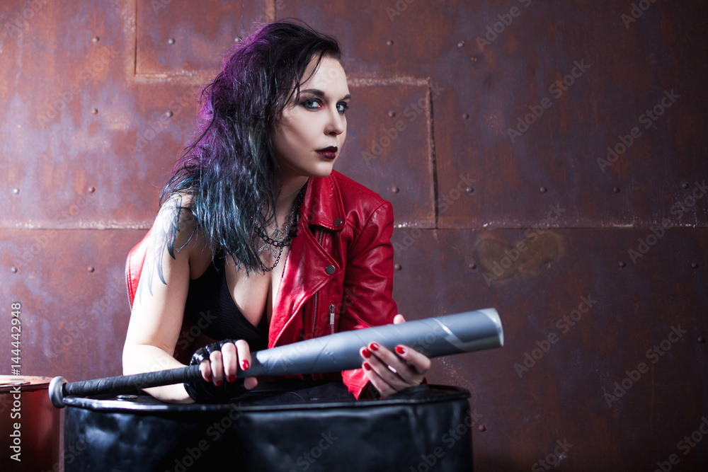 Aggressive punk woman with a bat, in red leather jacket Aggressive punk woman with a bat, in red leather jacket