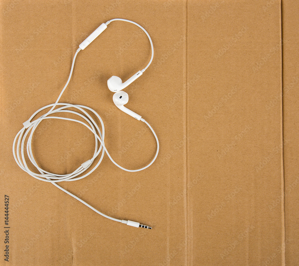 White headphone wires in the form of heart on cardboard. Love Music White headphone wires in the form of heart on cardboard. Love Music
