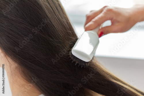 Hairdresser does hair style of woman