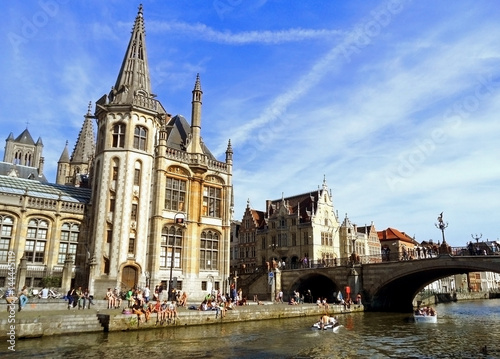 People chilling out at riverside In the afternoon of Sunday 18th May 2014, Ghent Historic Centre with Former Post Office and St Michael's Bridge, Belgium 
