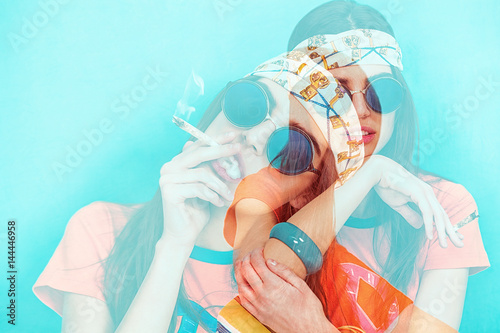 Double exposure of hippy girl portrait smoking weed and wearing sunglasses