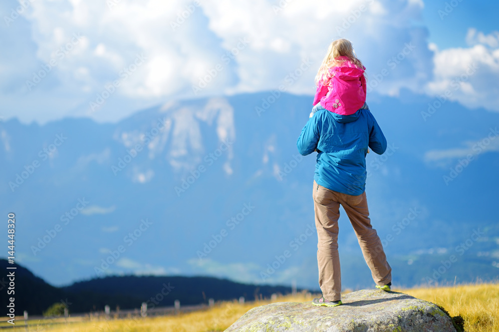 Father and his daughter admiring a view of stunning rocky Dolomites mountains of South Tyrol province of Italy