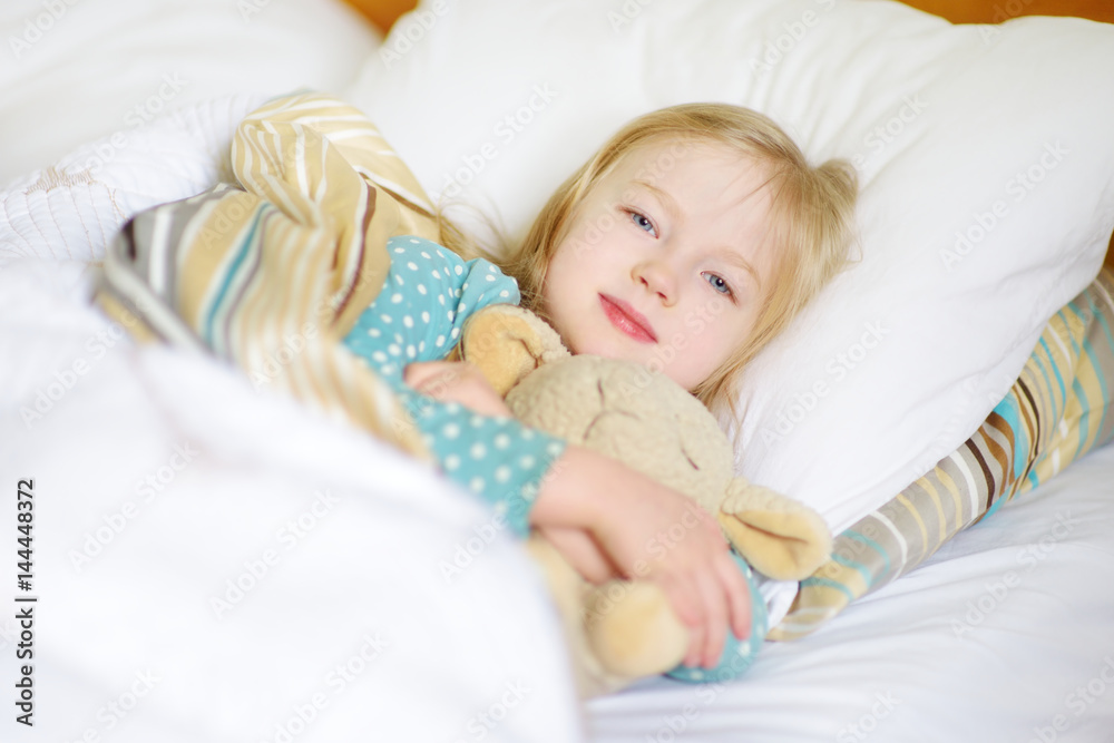 Adorable little girl sleeping in the bed with her toy Adorable little girl sleeping in the bed with her toy