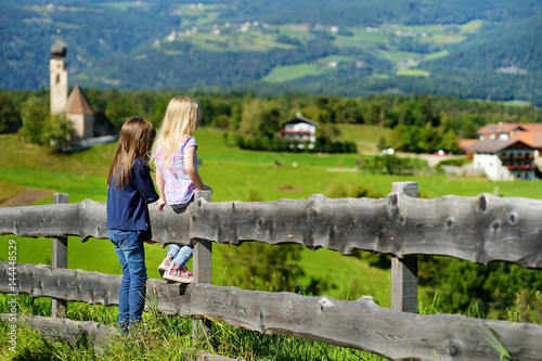 Two little sisters admiring beautiful landscape in Dolomites mountain range, South Tyrol province of Italy