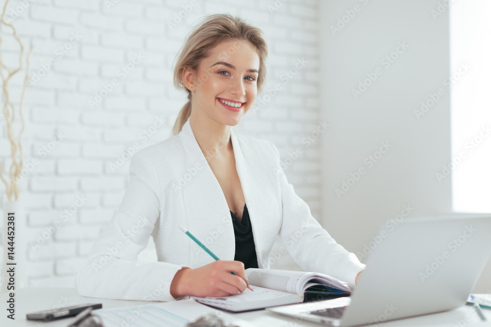 Portrait of beautiful young woman working in the office. Portrait of beautiful young woman working in the office.