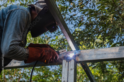 Welding steel by the male worker in industrial metal steel.