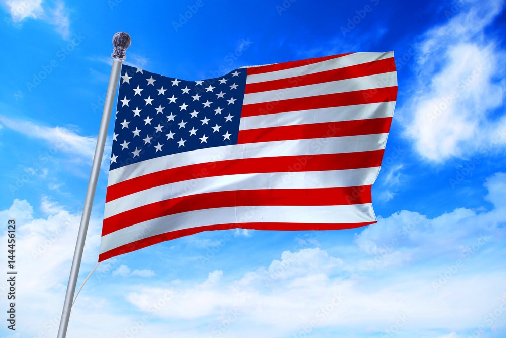 Obraz premium Flag of United States of America (USA) developing against a clear blue sky