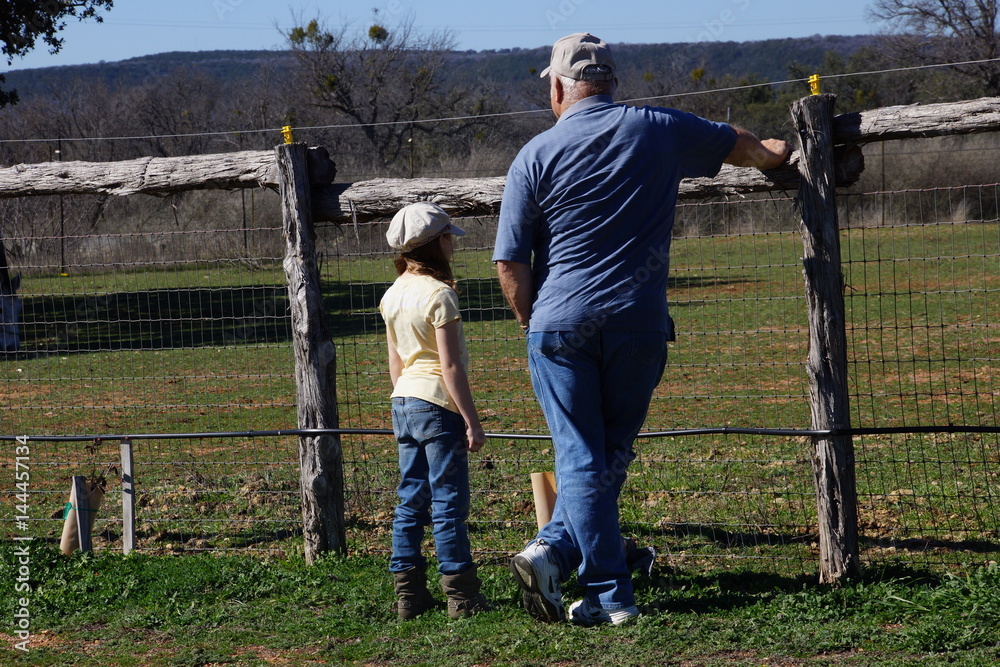 Grandpa and granddaughter talking in the pasture