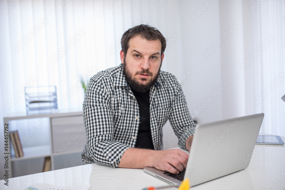 Handsome bearded businessman working with laptop in office Handsome bearded businessman working with laptop in office