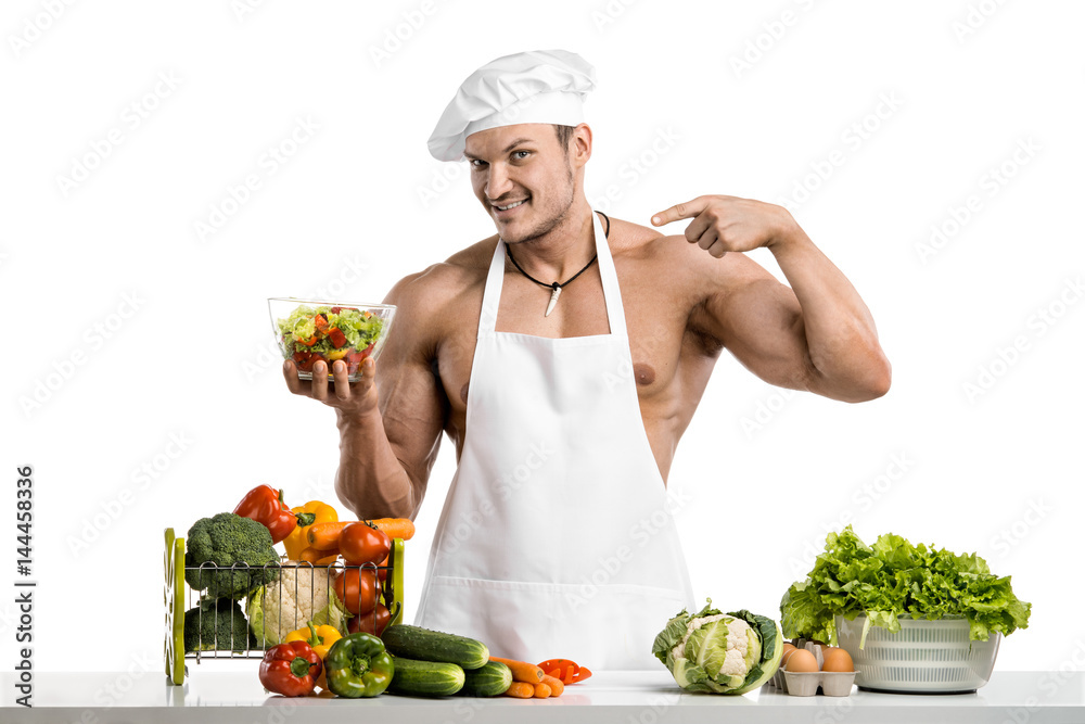 Man bodybuilder in white toque blanche and cook protective apron Man bodybuilder in white toque blanche and cook protective apron