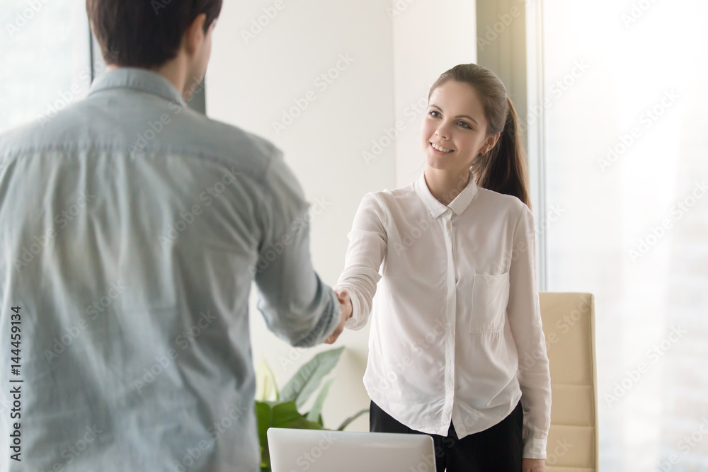 Fototapeta premium HR manager meeting with job applicant at the office for interview, two smiling business partners making agreement, greeting,handshaking, shaking hands before negotiations. Welcome to our team concept