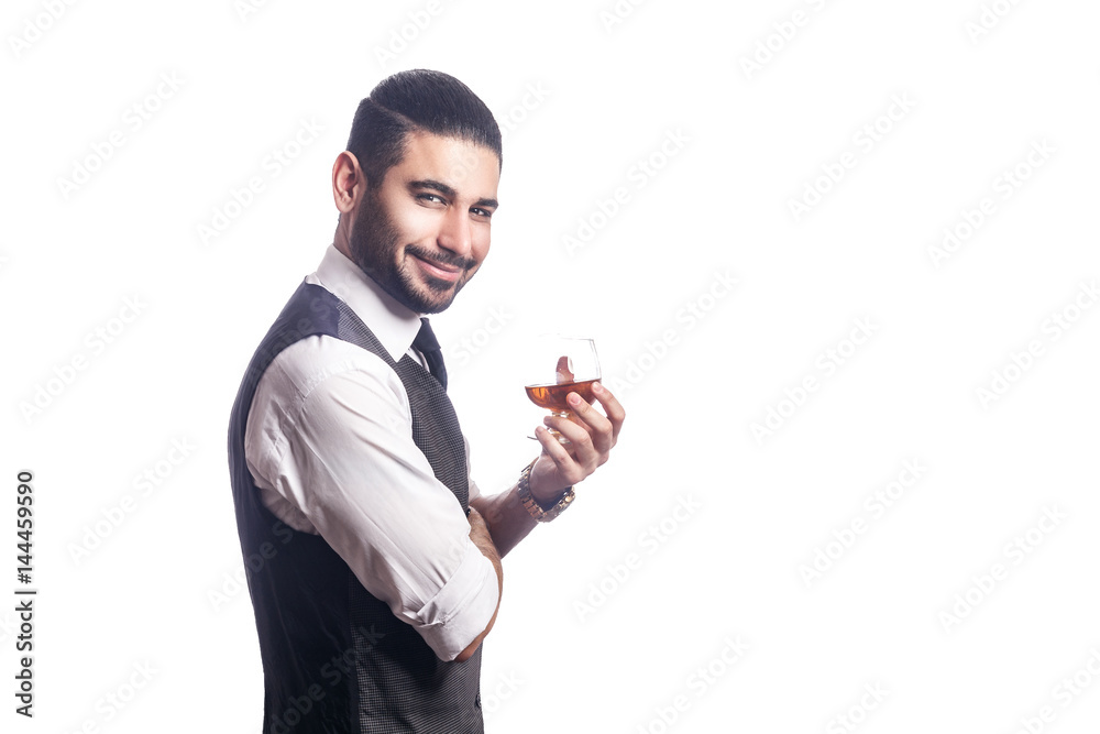 Handsome bearded businessman holding a glass of whiskey. holding glass and looking at camera with smile. studio shot, isolated on white background. Handsome bearded businessman holding a glass of whiskey. holding glass and looking at camera with smile. studio shot, isolated on white background.