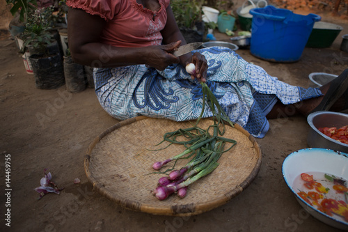 A African woman cutting onions in a Malawian Village