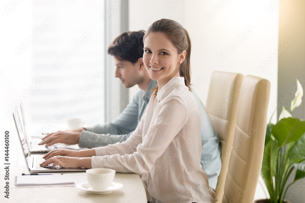 Fotografie Young business team working together using two laptops, portrait of female manag