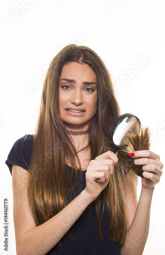 beautiful girl supprised and unhappy with her damaged and dry hair photo