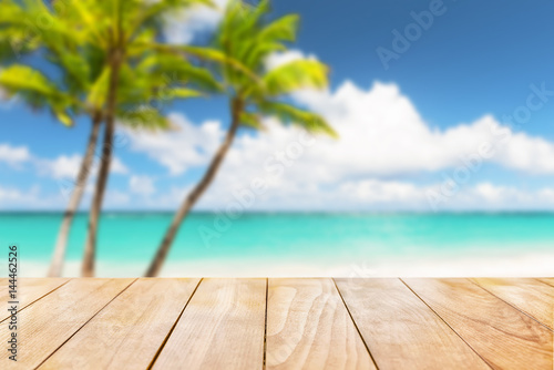 Wooden table top on blue sea and white sand beach