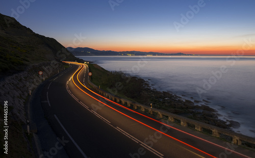 Car lights on the road at night by the sea  Gipuzkoa