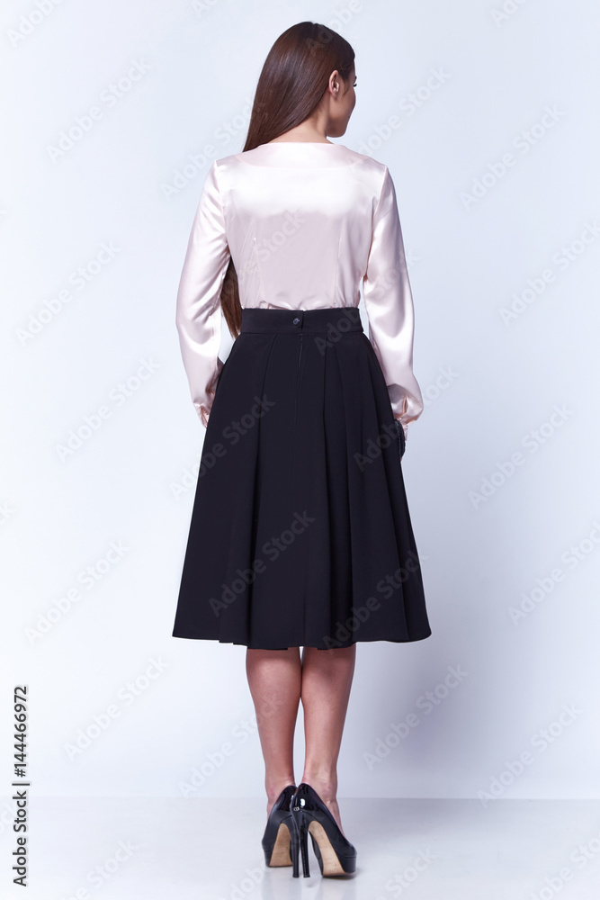 Beautiful woman lady spring autumn collection glamor model business office fashion clothes wear casual style beige color silk blouse cotton skirt black pretty face dark hair white background studio. Beautiful woman lady spring autumn collection glamor model business office fashion clothes wear casual style beige color silk blouse cotton skirt black pretty face dark hair white background studio.