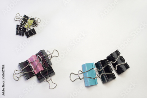 stacks of metal binder clips for paper. different sizes and colors