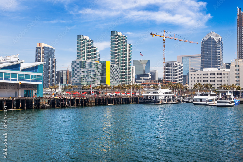 San Diego waterfront and skyline on Harbor Drive at Broadway Pier. Tower cranes dot the skyline and pleasure boats line the docks