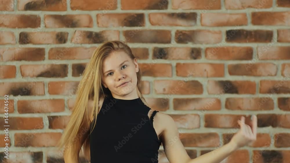 Hip hop girl dancing in modern style over urban brick wall Hip hop girl dancing in modern style over urban brick wall