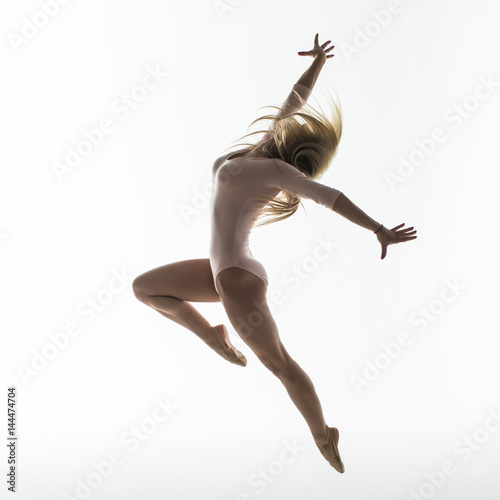Young slim gymnast in studio on white background