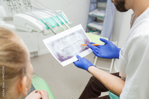 Dentist and woman examining a snapshot of teeth