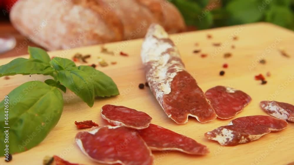 delicious homemade salami jerky sausages on a wooden board with basil