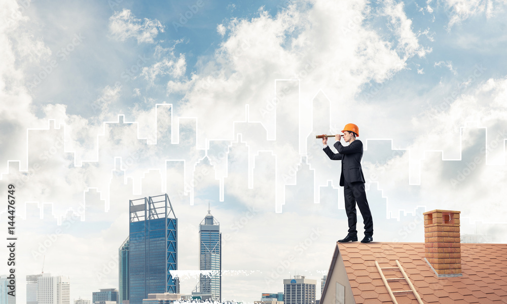 Engineer man standing on roof and looking in spyglass. Mixed med Engineer man standing on roof and looking in spyglass. Mixed med