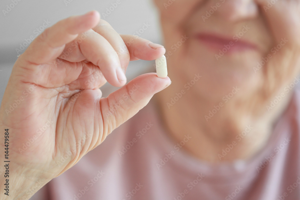 Hand of elderly woman with pill, closeup Hand of elderly woman with pill, closeup