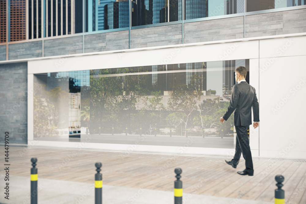 Businessman passing shopfront Businessman passing shopfront