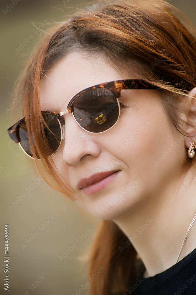 Woman wearing sunglasses and a yellow coat Woman wearing sunglasses and a yellow coat