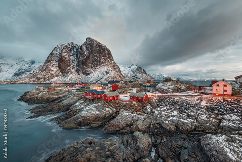 Fishing hut (rorbu) in the Hamnoy and Lilandstinden mountain peak at sunset - Reine, Lofoten islands, Norway photo