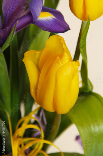 close photo of a yellow tulip in the bunch of flowers