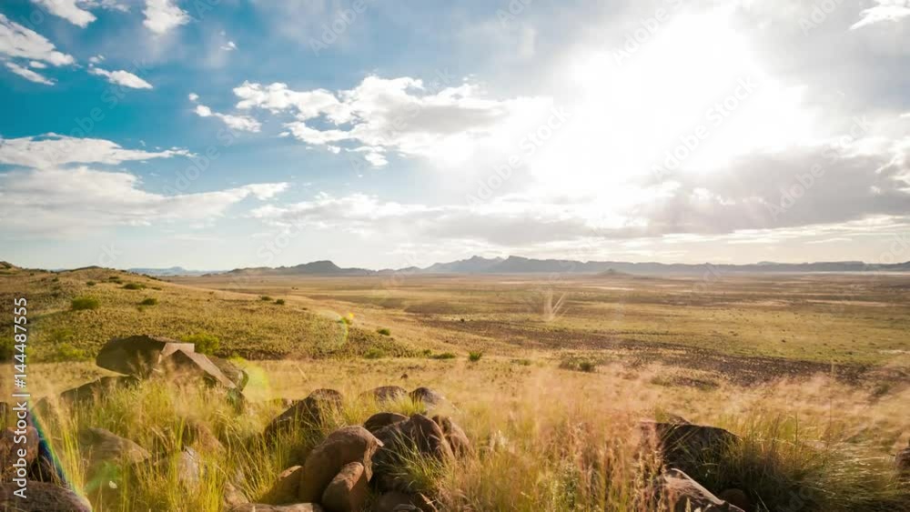 Holy grail linear timelapse showing the Karoo landscape and vistas stretched out down in the valley with a mountain in the distant background and rocks in the foreground.  Fast moving clouds blowing towards camera clearing up as it gets dark into the night with airglow in the sky available on request.